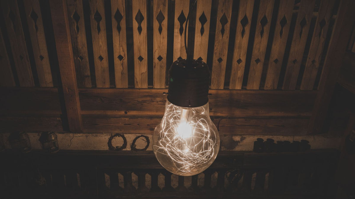 Ampoule à filament LED allumée dans un décor en bois chaleureux