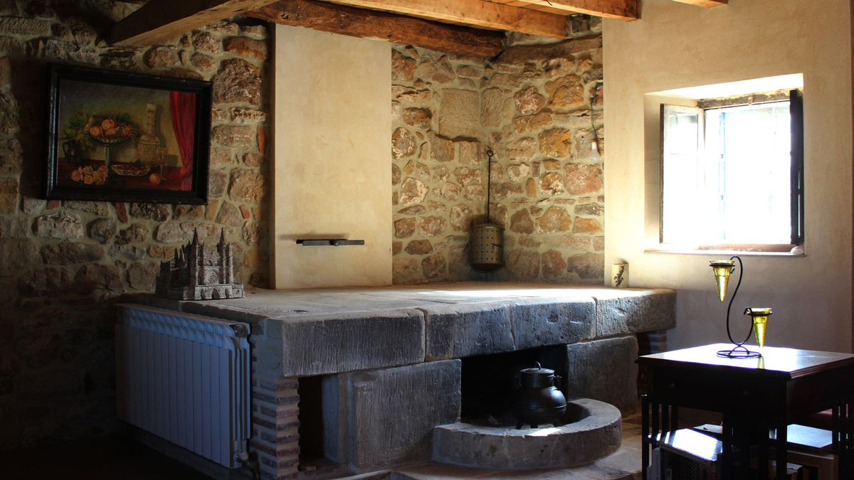 Cuisine aux murs de pierre et poutres en bois, ambiance chaleureuse
