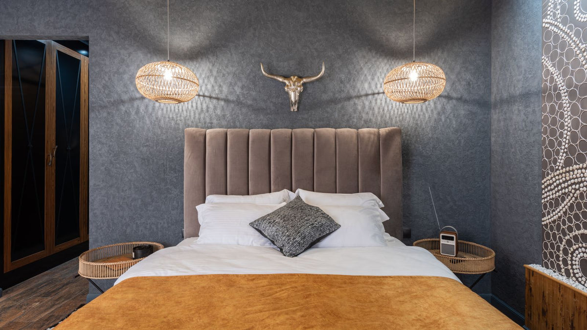 Chambre avec appliques murales en fibres naturelles au-dessus du lit