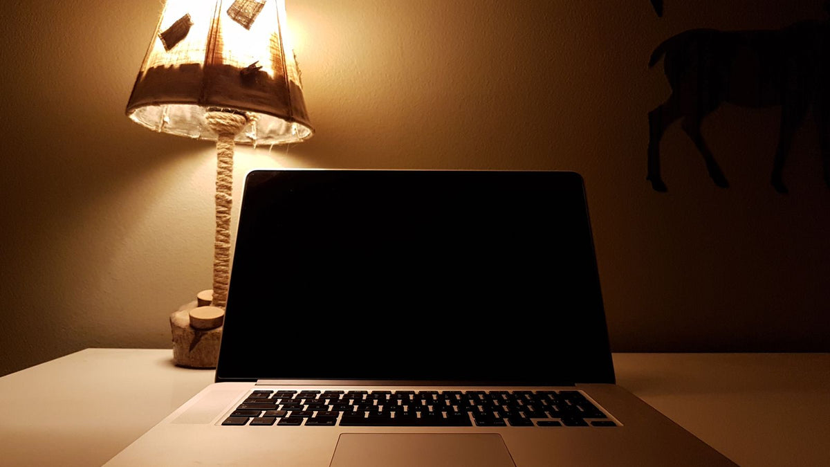 Lampe de table à la lumière chaude posée près d'un ordinateur portable