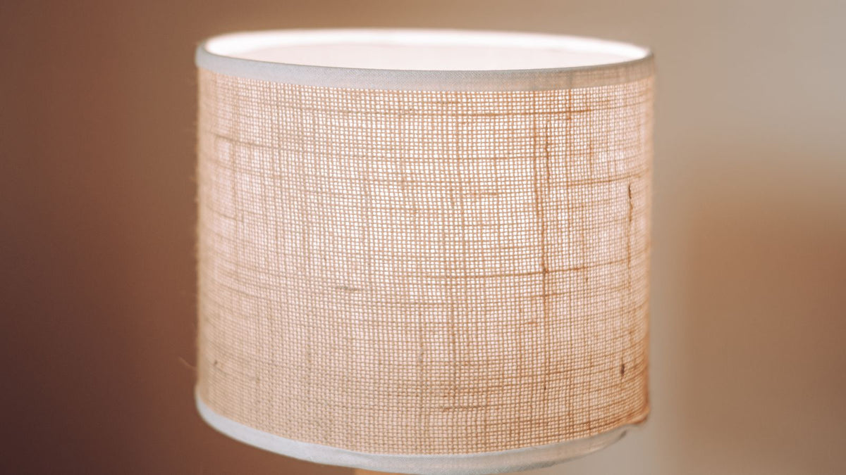 Abat-jour en lin clair allumé diffusant une lumière douce