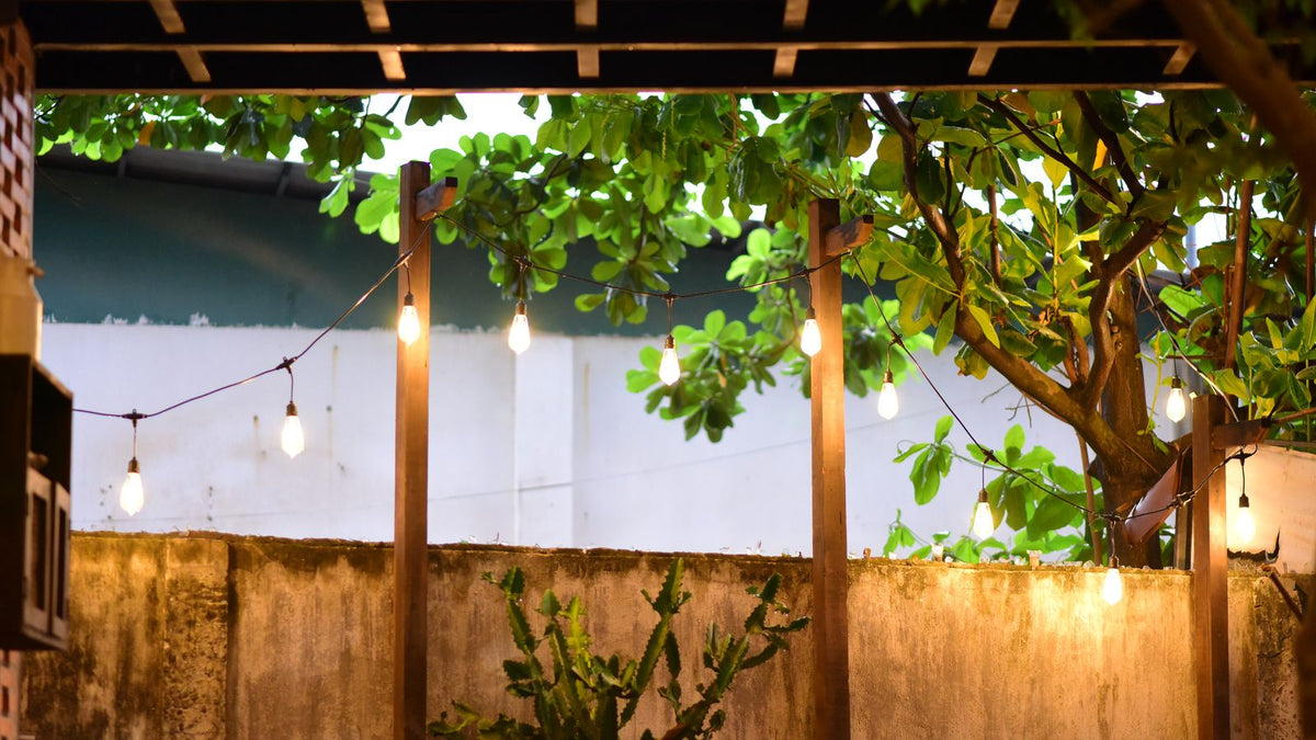 Terrasse de balcon éclairée par une guirlande lumineuse le soir
