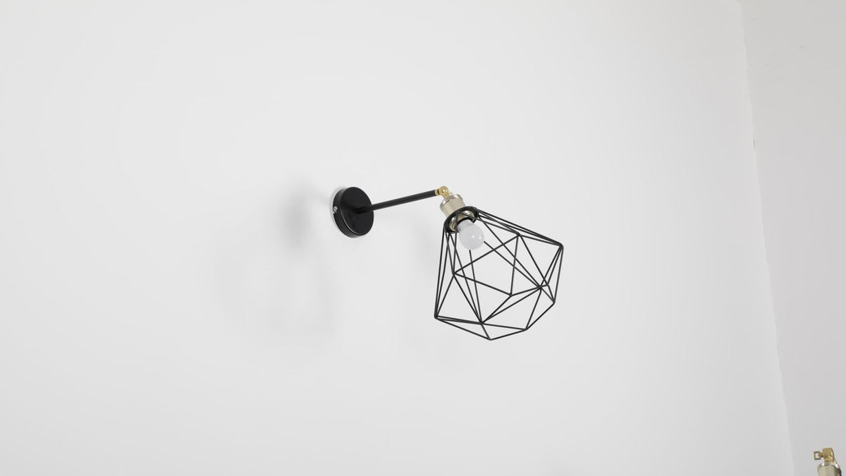 Applique cage en métal noir sur un mur clair, style pierre et métal