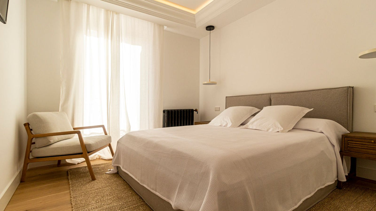 Chambre claire avec suspension discrète au-dessus du lit