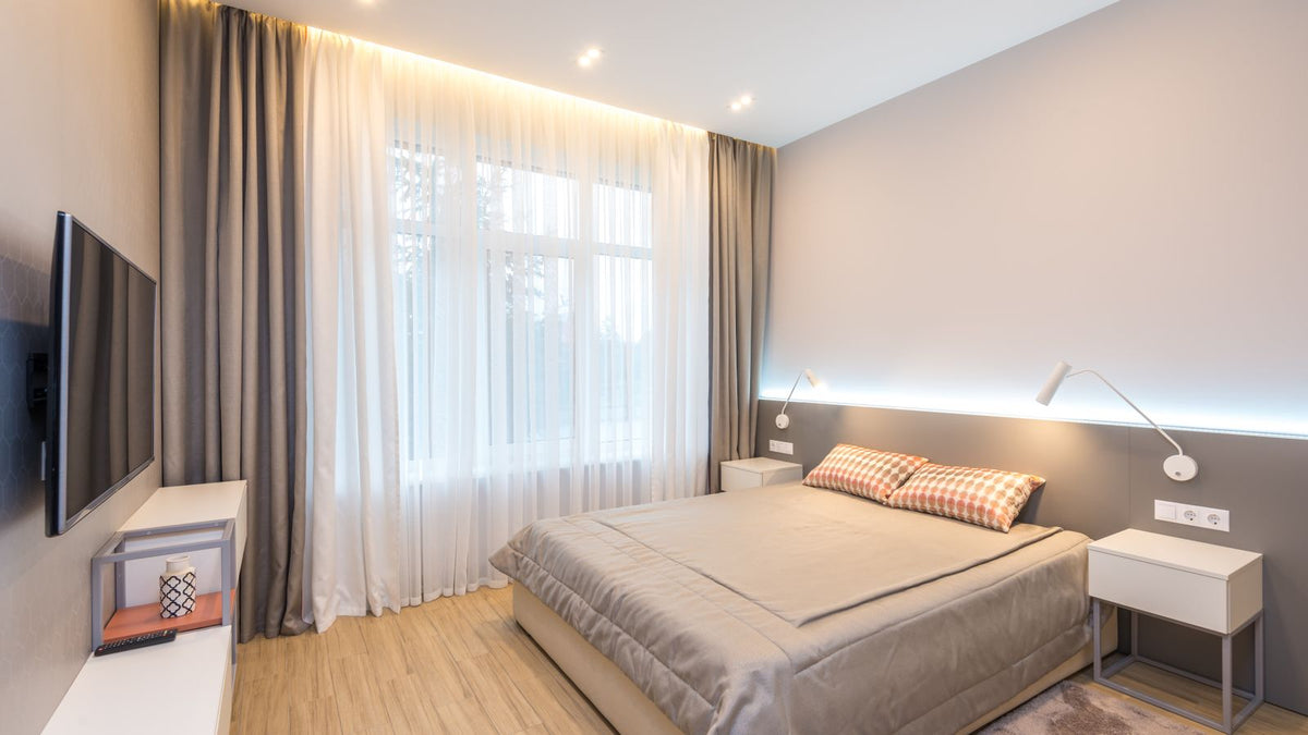 Chambre lumineuse avec applique murale à bras articulé près du lit