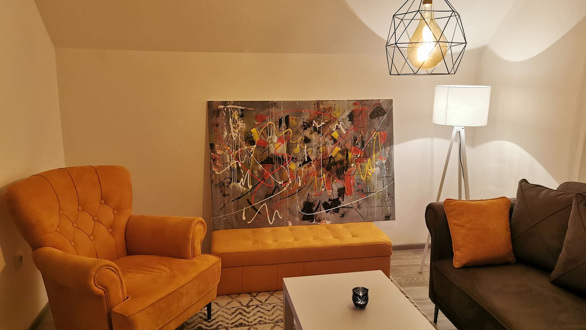 Salon chaleureux avec suspension et lampadaire près des fauteuils