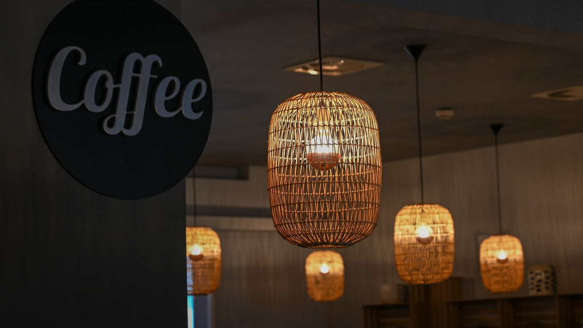 Café chaleureux éclairé par des suspensions en osier tressé