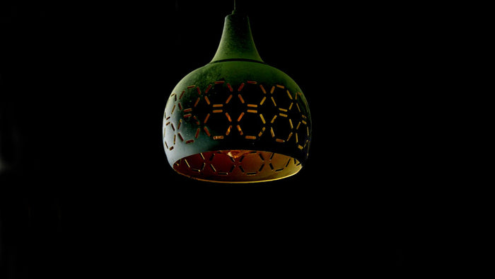 Suspension en métal aux motifs géométriques diffusant une lumière chaleureuse