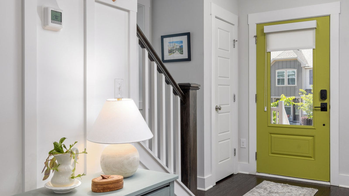 Entrée accueillante avec lampe à poser, console et porte verte