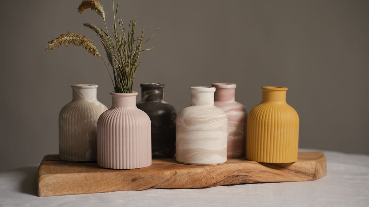 Vases en céramique mate posés sur un plateau en bois, déco wabi-sabi