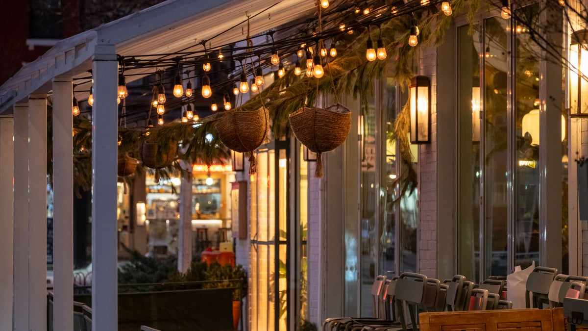 Terrasse de café chaleureuse éclairée par des guirlandes lumineuses