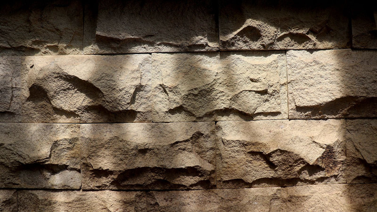 Mur en pierre texturé sublimé par une lumière rasante