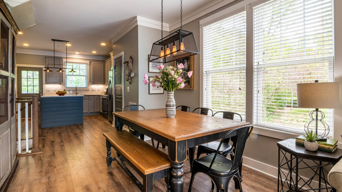 Salle à manger campagne chic avec table en bois et suspension