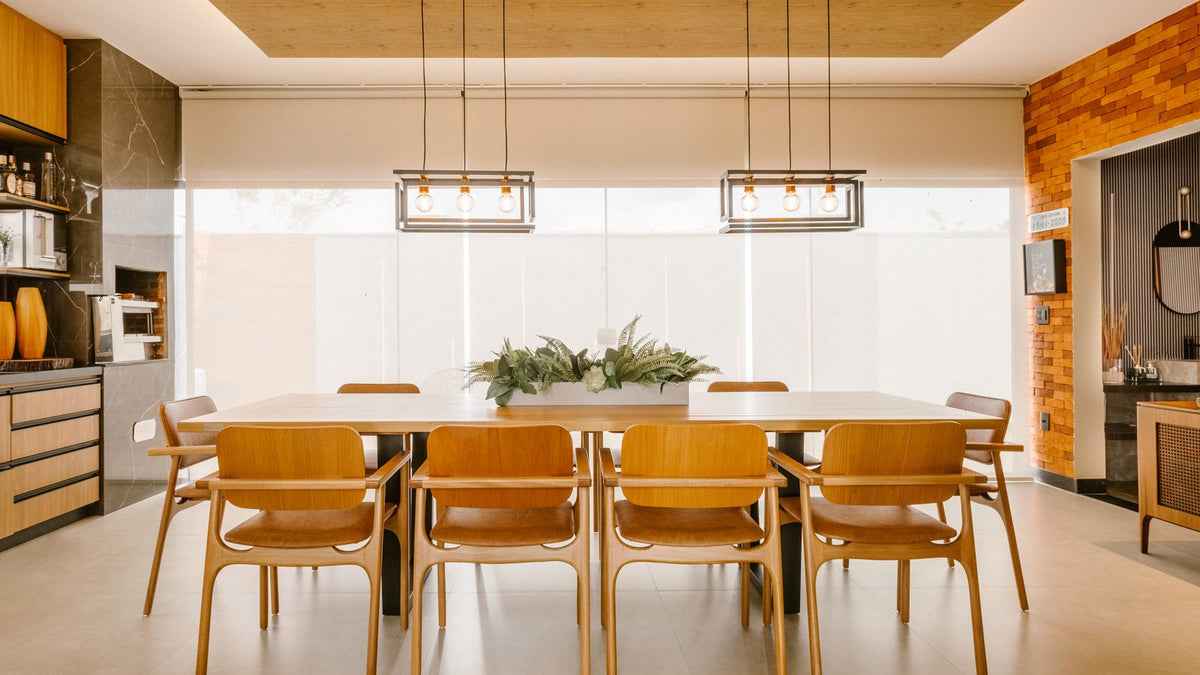 Salle à manger tendance avec suspensions linéaires et chaises en bois
