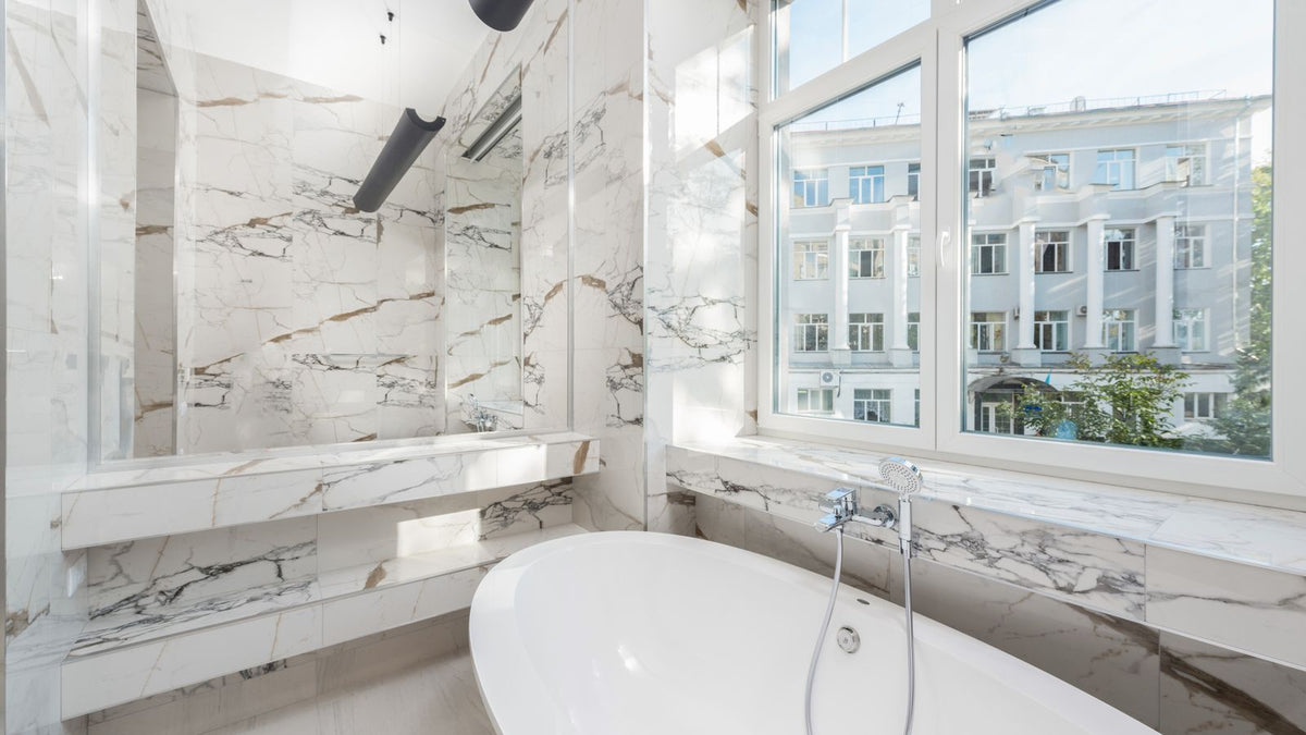 Salle de bain en marbre avec baignoire et vue dégagée