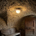 Plafonnier en travertin et bois, globe opalin, voûte de vieille pierre